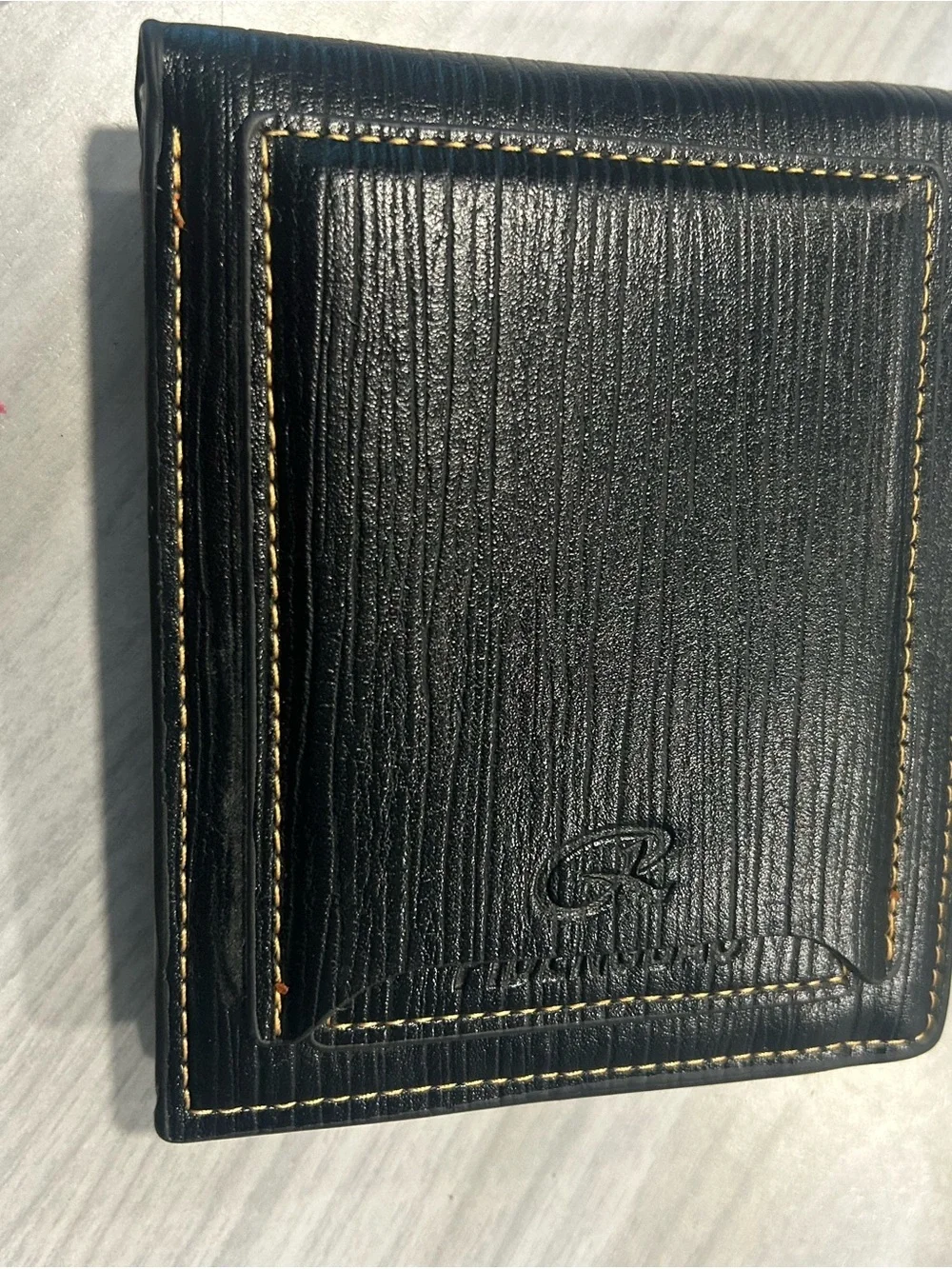 Men's Black Leather Bi-Fold Wallet with Embossed Face and Yellow Eye Accent